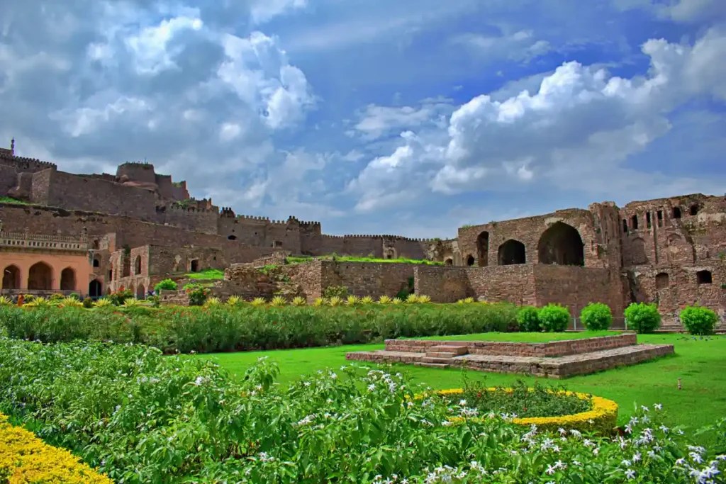 Ancient ramparts and manicured gardens of Golconda Fort under blue sky