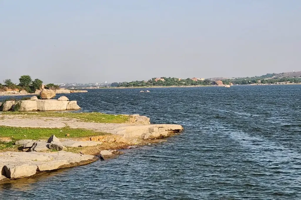 Rocky shoreline and calm evening waters of Shamirpet Lake