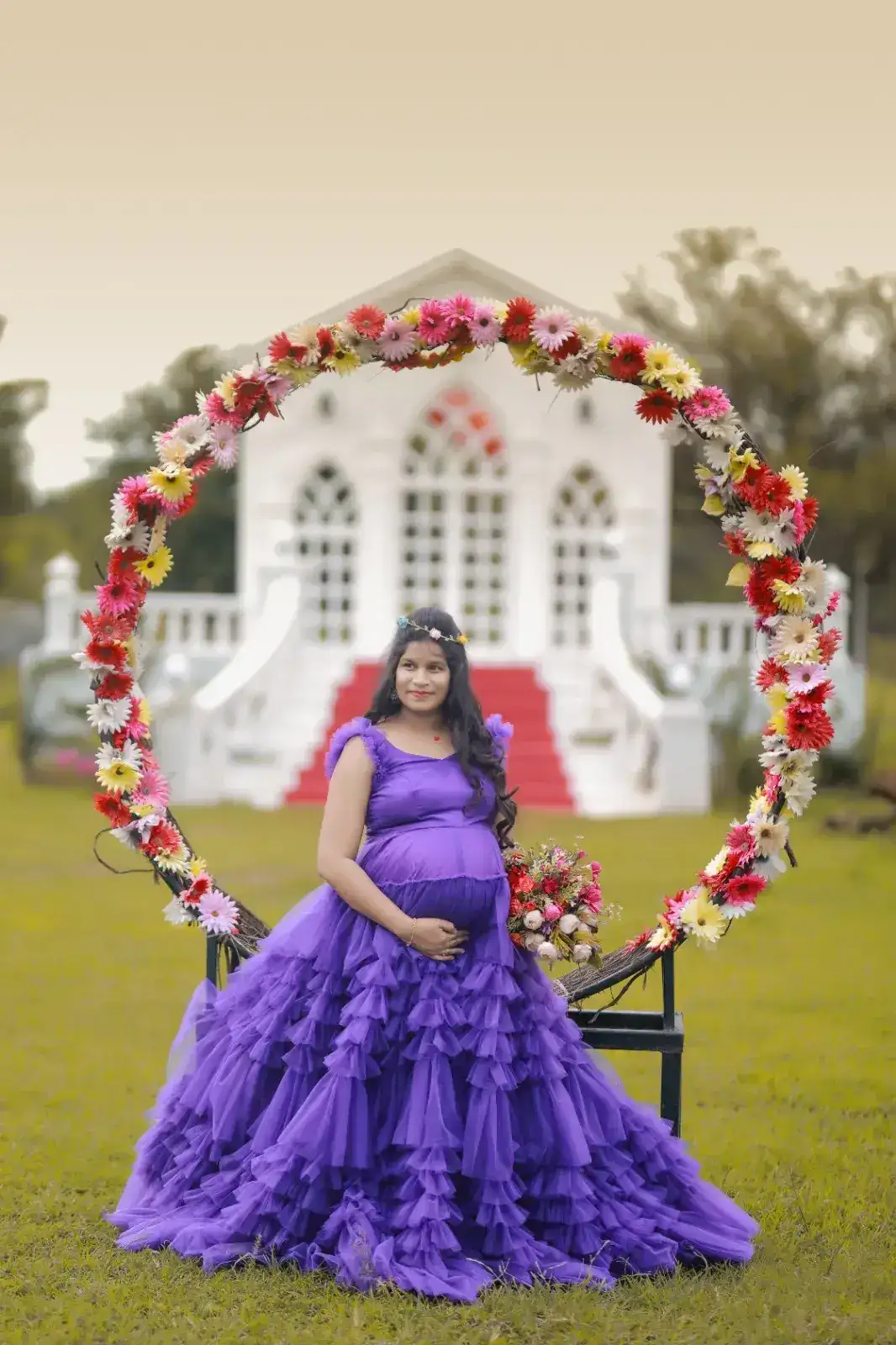 Pregnant mother in purple dress inside floral ring arch – Hyderabad maternity photoshoot