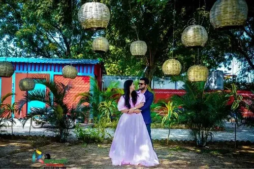 Couple under hanging bamboo lanterns in garden pre wedding shoot